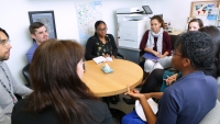 A group of people sitting in an office space having a discussion